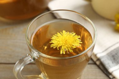 Ahşap masada çiçekli taze karahindiba çayı, yakın plan.