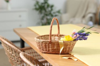 İçerideki masada güzel çiçekler olan hasır sepet.