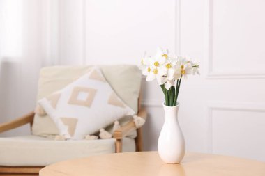 Evdeki ahşap masada vazodaki güzel nergisler. Metin için boşluk