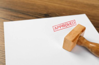 Sözcükle onaylanmış bir kağıt parçası ve ahşap masaya damgalanmış, yakın plan.