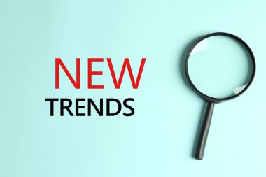 Yeni trendler. Turkuaz zemin üzerinde büyüteç, üst görünüm
