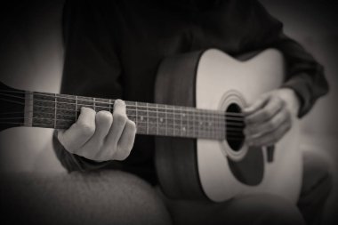 Gitar çalan adam, yakın plan. Siyah ve beyaz etkisi