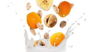 Süt, yulaf ezmesi ve beyaz arka planda kuru meyveler. Sağlıklı kahvaltı.