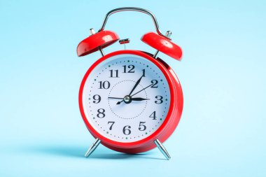 Açık mavi arkaplanda bir kırmızı alarm saati