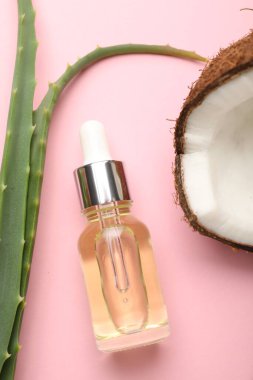 Saç tedavisi. Kozmetik ürün, hindistan cevizi ve aloe yaprakları pembe arka planda, düz konum
