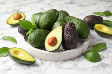 Avokadoların tamamı beyaz mermer masada, yakın plan.