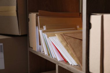 Postanede farklı kağıt zarflar ve paketler var.