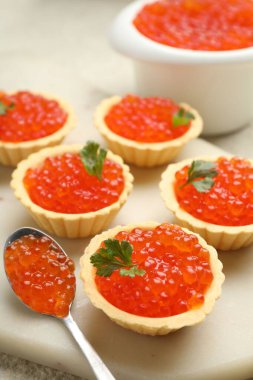 Kırmızı havyarlı tart ve bej masadaki maydanoz, yakın plan.