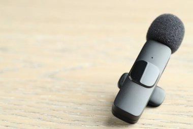 Lavalier mikrofonu ahşap masada, yakın plan. Metin için boşluk