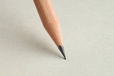 Hafif arkaplanda keskin bir grafit kalem, yakın plan.