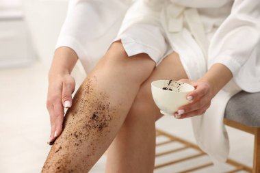 Kadın bacağını içeride ovuyor, yakın plan.