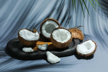 Gri arka planda tropikal palmiyelerin taze hindistan cevizleri ve gölgesi, yakın plan