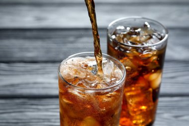 Gri ahşap masada ferahlatıcı kolayı cama boşalt.