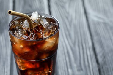 Buzlu kolayı tazeliyorum ve bulanık gri arka planda bardakta saman var, yakın plan. Metin için boşluk