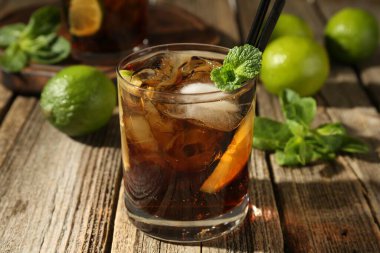 Küba libre kokteylini ahşap masada nane şekeri ile tazeliyorum.