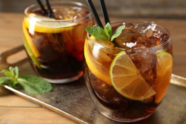 Küba libre kokteylini ahşap masada nane şekeri ile tazeliyorum.