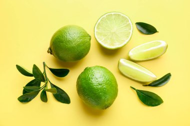 Sarı arka planda taze limonlar, düz uzanmış.