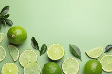 Taze limon ve yapraklar soluk yeşil arka planda, düz yatıyordu. Metin için boşluk