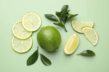 Taze limon ve yapraklar soluk yeşil arka planda, düz yatıyordu.