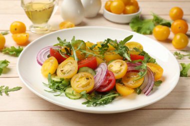 Beyaz ahşap masada sarı domatesli taze salata, yakın plan.