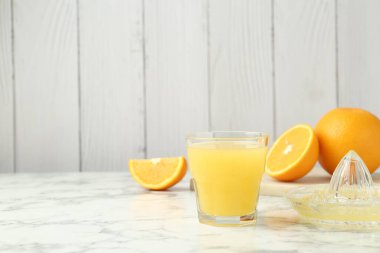 Taze portakal suyu, meyveler ve beyaz mermer masa üzerinde ahşap arka planda, yakın plan. Metin için boşluk