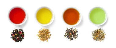 Farklı türde kurutulmuş çay yaprakları ve beyaz arka planda demlenmiş içecekler. Üst görünüm