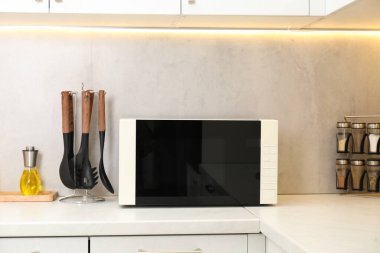 Mutfak tezgahında kapalı mikrodalga fırın.