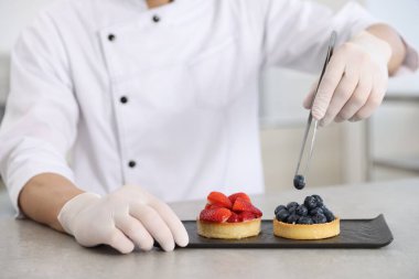 Mutfaktaki gri masada yaban mersinli lezzetli tart, yakın plan.