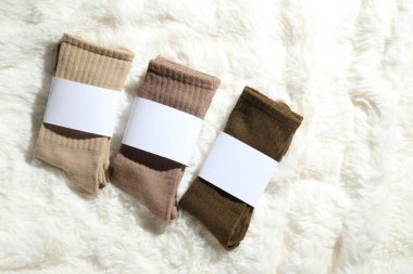 Beyaz sahte kürkte farklı yumuşak çoraplar, üst manzara. Metin için boşluk