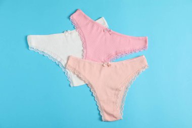 Kadın iç çamaşırı. Açık mavi arka planda güzel külotlar, düz yatış