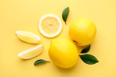 Sarı arka planda taze olgun limonlar, düz uzanmış.