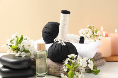 Bitkisel poşetler, güzel çiçekler ve yanan mumlar bej arka planda, yakın plan