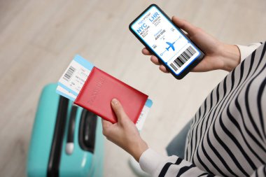 İçinde uçak ve pasaport olan cep telefonlu turistler, yakın plan.
