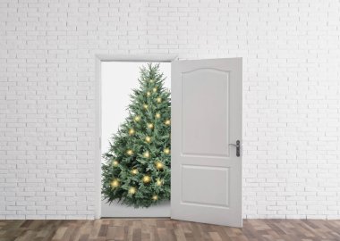 Kapının önünde şenlik ışıkları olan güzel bir Noel ağacı. Tatil sezonu