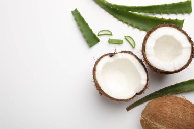 Saç tedavisi. Beyaz arka planda hindistan cevizi ve aloe yaprakları düz. Metin için boşluk