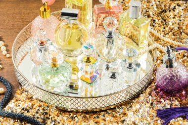 Tahta masadaki farklı lüks parfümler ve aksesuarlar.