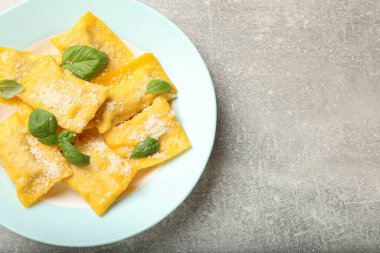 Peynirli ve fesleğenli leziz ravioli, gri masa, üst manzara. Metin için boşluk