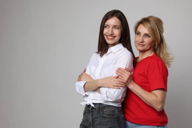 Açık gri arka planda anne ve kızının portresi. Metin için boşluk