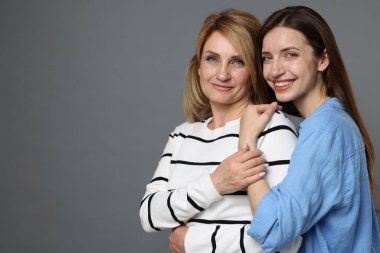 Gri arka planda anne ve kızının portresi. Metin için boşluk