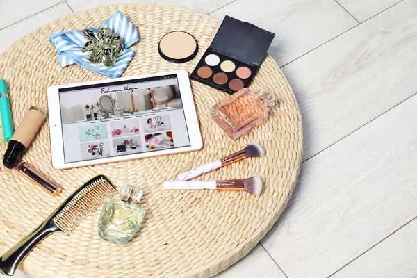 Moda blogu sitesi olan tablet, yerde farklı aksesuarlar ve makyaj ürünleri var. Metin için boşluk