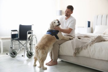Özürlü bir adam ve hizmetli köpeği evde.