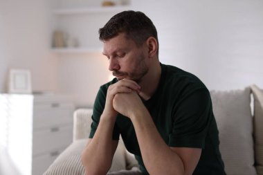 Evdeki kanepede depresif bir adam. Zihinsel sağlık sorunu