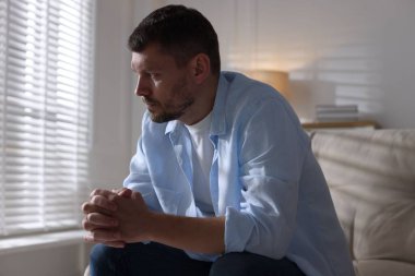 Evdeki kanepede depresif bir adam. Zihinsel sağlık sorunu