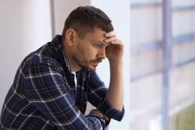 Binanın penceresinin yanında depresif bir adam var. Zihinsel sağlık sorunu