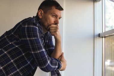 Binanın penceresinin yanında depresif bir adam var. Zihinsel sağlık sorunu