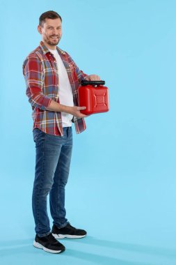 Açık mavi arkaplanda plastik kutu tutan adam, metin için boşluk