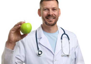 Beyaz arka planda yeşil elmalı ve steteskoplu beslenme uzmanı.
