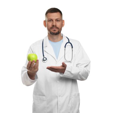 Beyaz arka planda yeşil elmalı ve steteskoplu beslenme uzmanı.