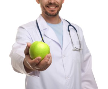 Beyaz arka planda yeşil elmalı ve steteskoplu beslenme uzmanı, yakın plan.