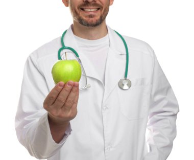 Beyaz arka planda yeşil elmalı ve steteskoplu beslenme uzmanı, yakın plan.